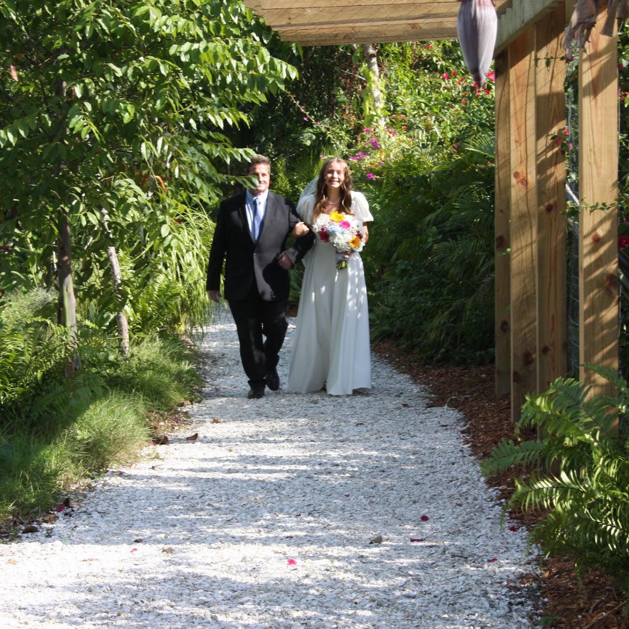 Bride walking down garden path at tropical island wedding venue